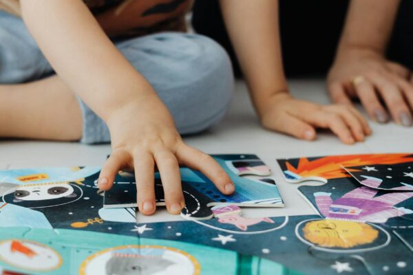 vaikai žaidžia su lavinamaisiais žaislais kartu su tėvais, ugdydami įgūdžius ir kūrybiškumą